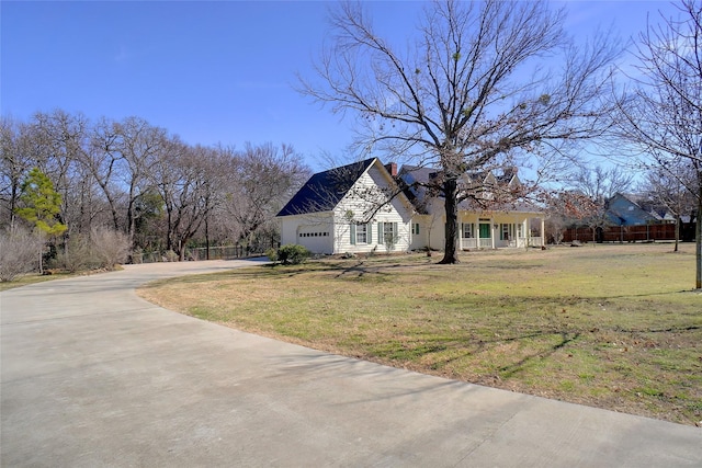 view of front of home with a garage, a chimney, a front lawn, and concrete driveway