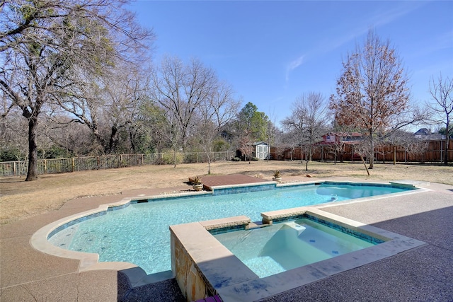 view of swimming pool featuring a storage shed, a fenced backyard, a pool with connected hot tub, and an outdoor structure