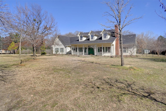 cape cod-style house with covered porch and a front lawn