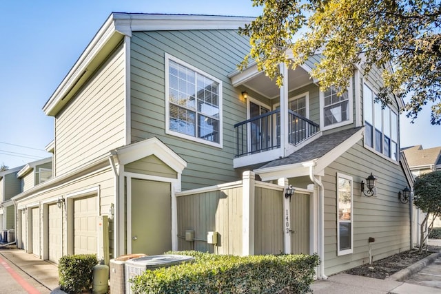 exterior space featuring a garage, central AC, and a balcony