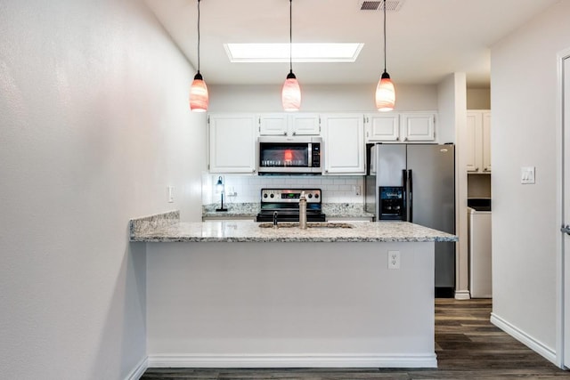 kitchen featuring white cabinetry, a skylight, appliances with stainless steel finishes, tasteful backsplash, and pendant lighting