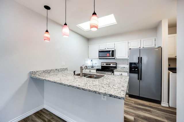 kitchen featuring kitchen peninsula, a skylight, appliances with stainless steel finishes, and sink