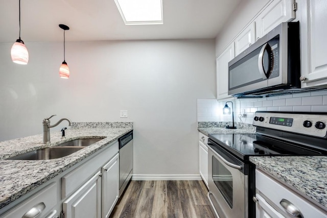 kitchen with white cabinetry, stainless steel appliances, backsplash, pendant lighting, and sink