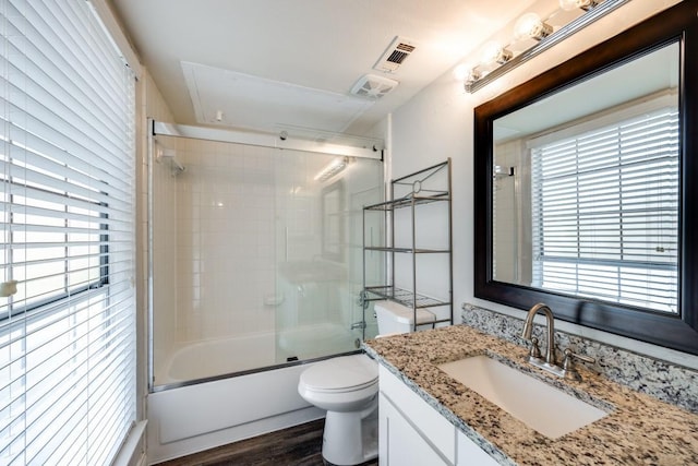 full bathroom with toilet, hardwood / wood-style flooring, vanity, and shower / bath combination with glass door