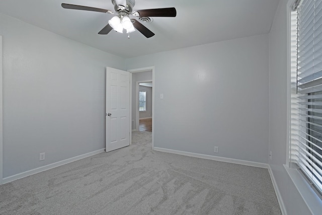 carpeted spare room featuring ceiling fan