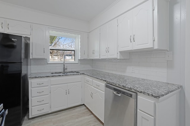 kitchen with backsplash, black fridge, stainless steel dishwasher, sink, and white cabinets