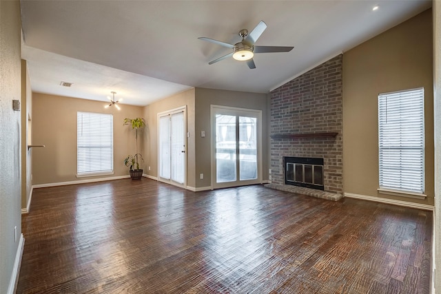 unfurnished living room with a fireplace, ceiling fan with notable chandelier, dark hardwood / wood-style floors, and vaulted ceiling