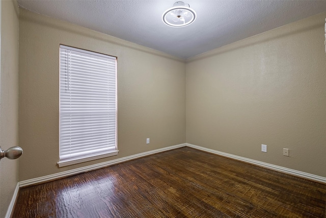 spare room with dark wood-type flooring