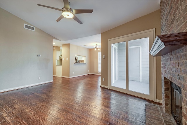 unfurnished living room with a brick fireplace, vaulted ceiling, dark hardwood / wood-style floors, and ceiling fan