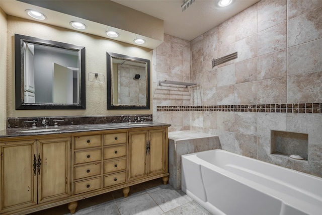 bathroom with tile patterned floors, vanity, and a bath