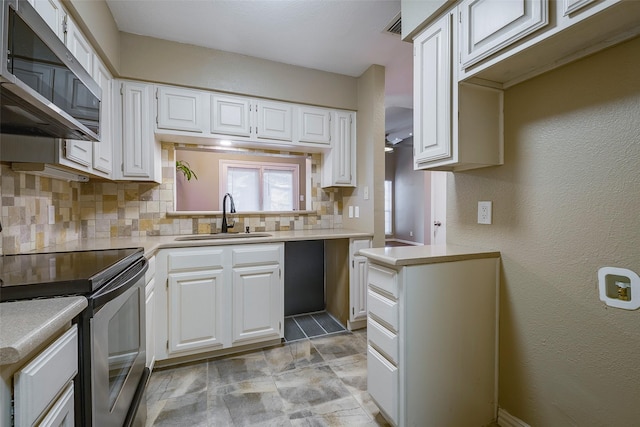 kitchen with white cabinetry, sink, decorative backsplash, and appliances with stainless steel finishes