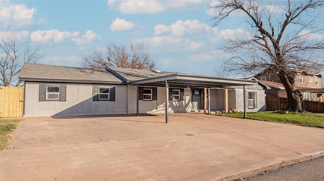 ranch-style home featuring a carport and a front yard