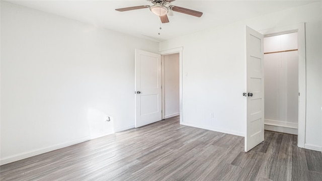 unfurnished bedroom featuring hardwood / wood-style floors, a closet, and ceiling fan