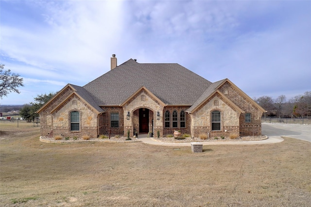 french country inspired facade with a front yard