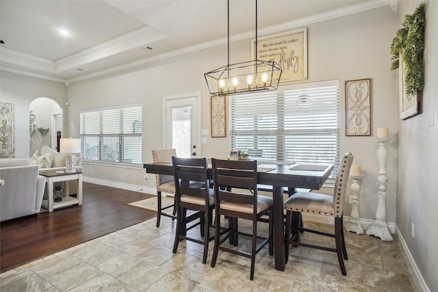 dining room featuring hardwood / wood-style floors, a tray ceiling, an inviting chandelier, and crown molding