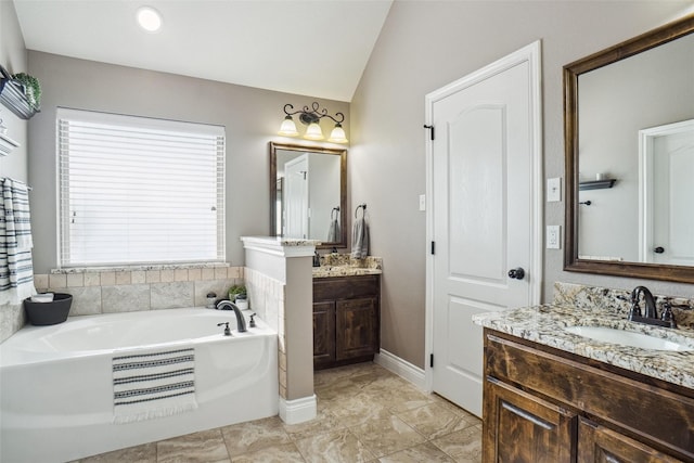 bathroom featuring a tub, vanity, and lofted ceiling