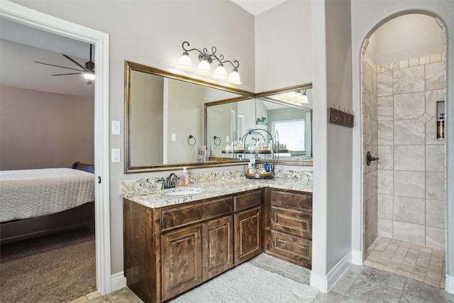 bathroom with a tile shower, ceiling fan, and vanity