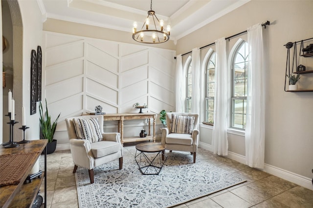 sitting room with a raised ceiling, ornamental molding, and an inviting chandelier