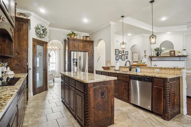 kitchen with dark brown cabinetry, a center island, pendant lighting, and appliances with stainless steel finishes