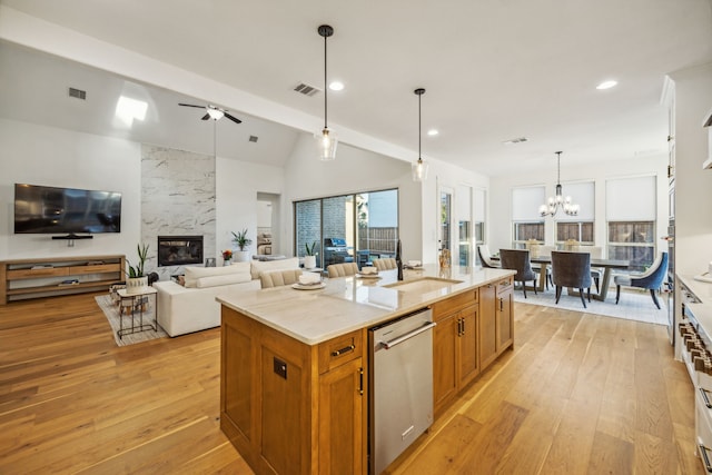 kitchen with sink, stainless steel dishwasher, an island with sink, decorative light fixtures, and ceiling fan with notable chandelier