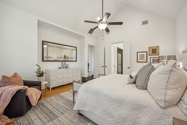 bedroom featuring ceiling fan, light hardwood / wood-style flooring, and high vaulted ceiling