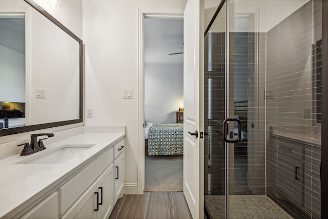 ensuite bathroom with a shower stall, vanity, wood finished floors, and ensuite bathroom