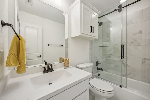 bathroom featuring toilet, combined bath / shower with glass door, vanity, and visible vents