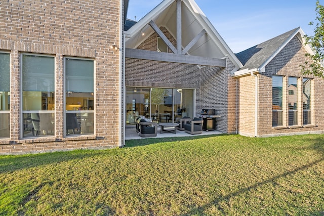 back of property featuring a patio area, a lawn, and brick siding