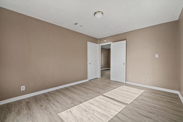 unfurnished bedroom featuring baseboards, visible vents, and light wood-type flooring