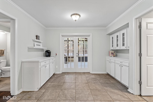 interior space featuring white cabinets, light tile patterned floors, crown molding, and french doors