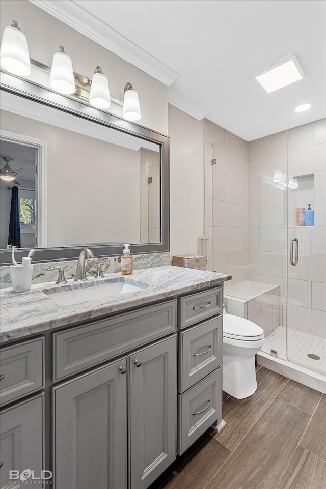 bathroom featuring toilet, vanity, ornamental molding, and walk in shower