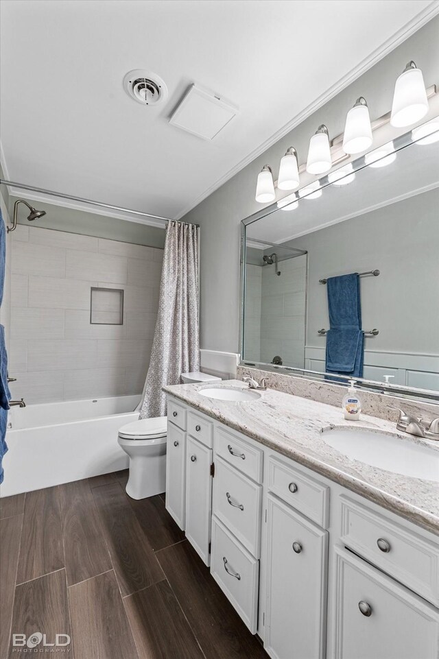 full bathroom featuring crown molding, shower / bath combo with shower curtain, vanity, and toilet