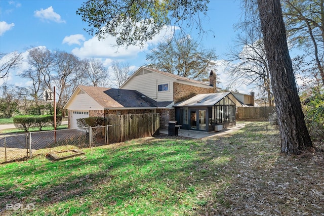 back of house featuring central AC, a lawn, and a sunroom