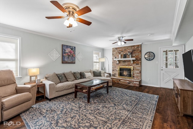 living room with ceiling fan, dark hardwood / wood-style flooring, crown molding, and a brick fireplace