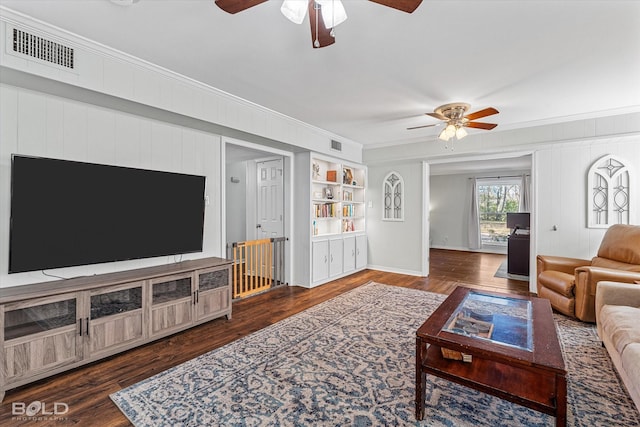 living room with dark hardwood / wood-style floors, built in features, and crown molding