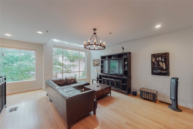 living room featuring light hardwood / wood-style floors and an inviting chandelier