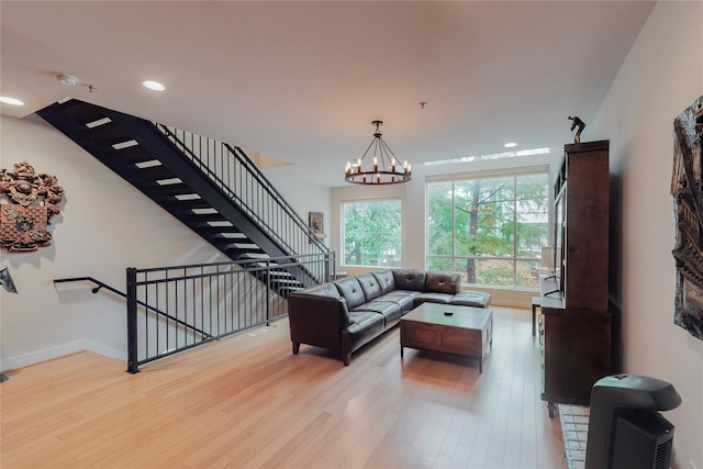 living room with light hardwood / wood-style floors and a notable chandelier