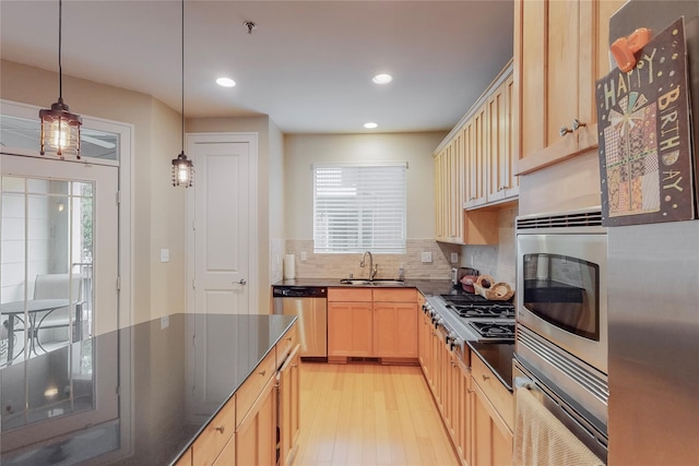 kitchen with pendant lighting, light brown cabinets, sink, a wealth of natural light, and appliances with stainless steel finishes