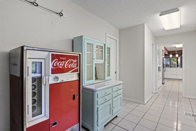 interior space with light tile patterned floors and a textured ceiling