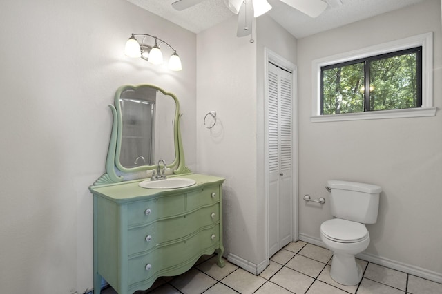 bathroom with tile patterned flooring, vanity, ceiling fan, toilet, and a textured ceiling