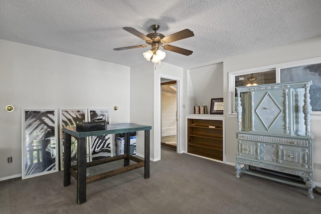 office featuring dark colored carpet, a textured ceiling, and ceiling fan