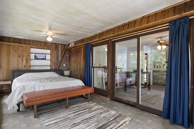 bedroom featuring access to exterior, ceiling fan, and wooden walls