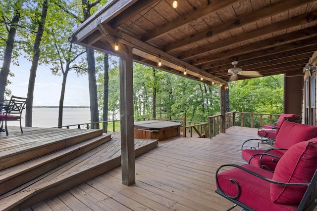 wooden terrace featuring a covered hot tub, ceiling fan, and a water view