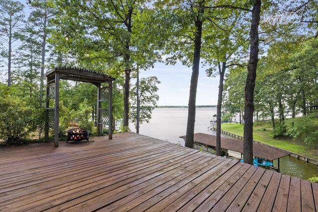 deck with a water view, a dock, and an outdoor fire pit