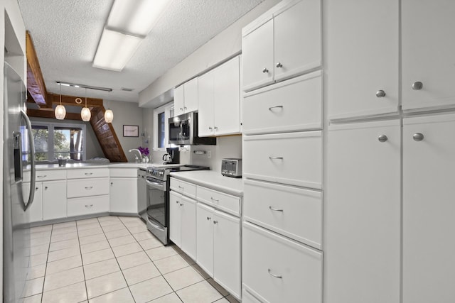 kitchen with decorative light fixtures, white cabinetry, light tile patterned floors, stainless steel appliances, and a textured ceiling