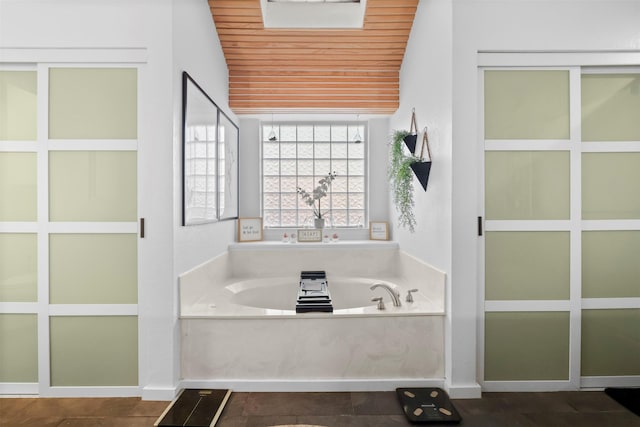 bathroom with wooden ceiling and a bathing tub