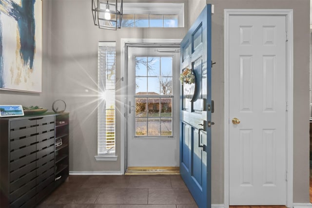 entrance foyer with a wealth of natural light and dark tile patterned flooring