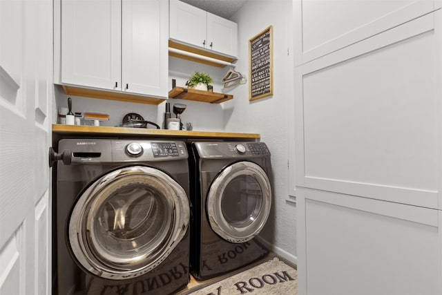 laundry area with separate washer and dryer and cabinets