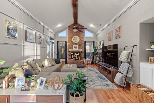 living room featuring high vaulted ceiling, light hardwood / wood-style flooring, ceiling fan, ornamental molding, and beam ceiling