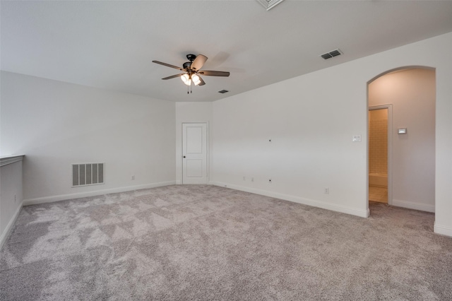 empty room with ceiling fan and light carpet